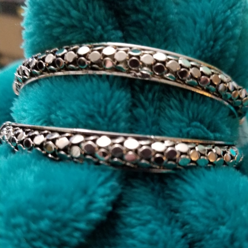 Set of two silvertone hinged bangle bracelets.